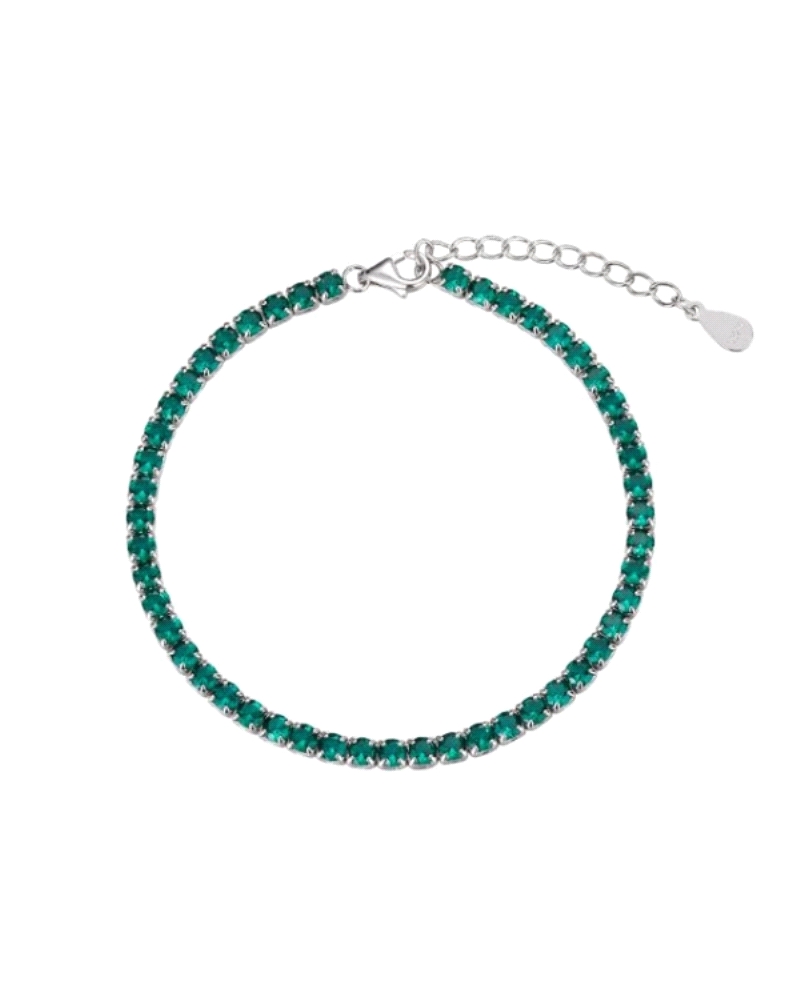 Una pulsera de circonita rodinada "rivière" de 3 mm con garras en color esmeralda sería una elección espectacular y elegante. Es