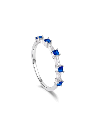 Este elegante anillo de plata rodiada presenta circonitas en tono zafiro, cada una asegurada por delicadas garras que realzan su