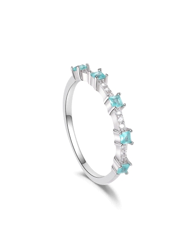 Este impresionante anillo de plata rodiada está adornado con circonitas azules, cada una asegurada por garras que resaltan su br