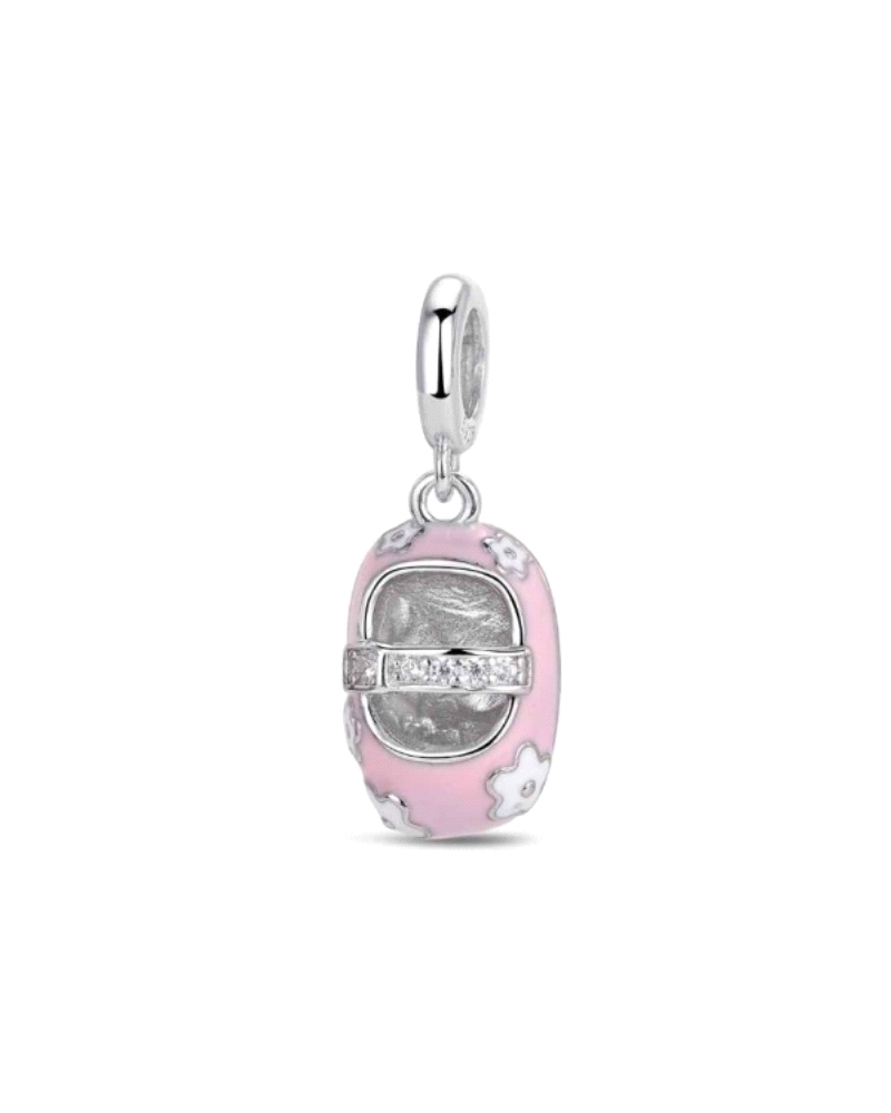 Abalorio de plata con forma de zapatito, delicadamente esmaltado en rosa. Este adorable accesorio evoca la dulzura y la ternura,