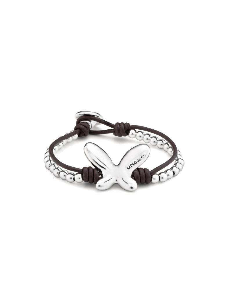 Pulsera bañada en plata con un diseño doble con una tira de cuero y una mariposa central. . Dispone de un elegante y cómodo cier