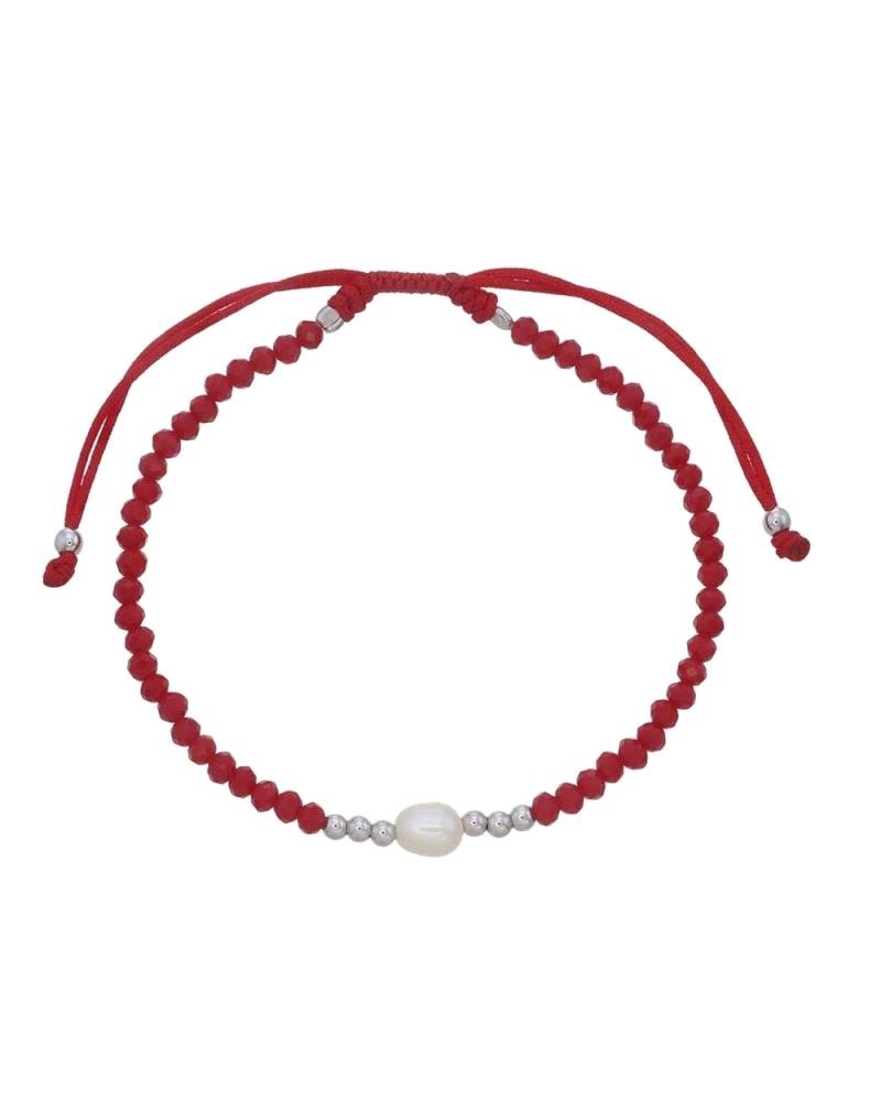 Esta pulsera tiene un diseño sencillo y elegante, compuesto por un cordón rojo ajustable decorado con cuentas rojas. En el centr