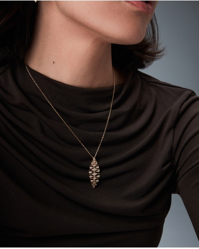 Un collar realizado en plata de primera ley con un delicado baño de oro, destaca por su colgante articulado en forma de hoja, sí