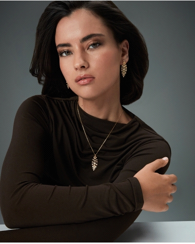 Un collar realizado en plata de primera ley con un delicado baño de oro, destaca por su colgante articulado en forma de hoja, sí