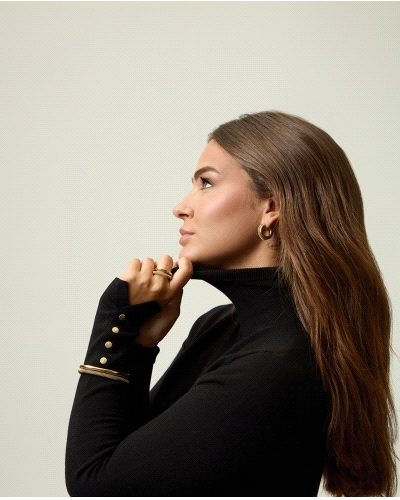 Esta pulsera de acero Ip dorado de la colección Laura Escanes es una pieza elegante y moderna, con un diseño rígido doble que co