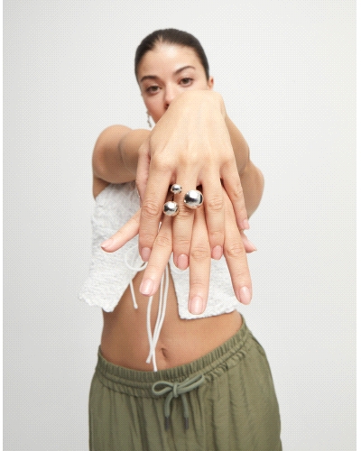 Este anillo abierto bañado en plata rompe con lo convencional gracias a su diseño orgánico de burbujas en distintos tamaños. Una