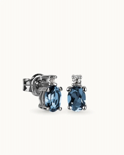 Pendientes en plata de ley rodiada con dos topacios london blue en talla oval 7x5mm y dos topacios blancos.