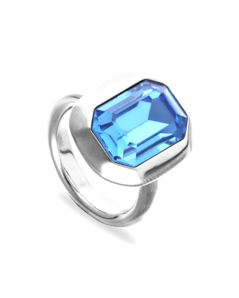 Espectacular anillo con gran cristal azul facetado en talla llamada esmeralda, fabricado en metal bañado en plata.